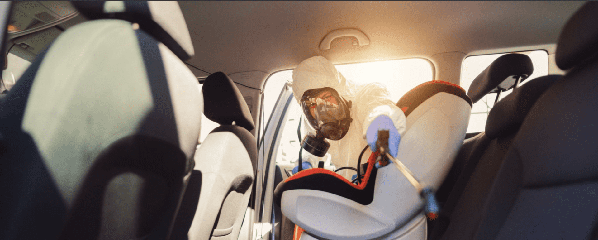 Homeen poistaminen auton sisätiloista – ammattilainen siivoamassa auton verhoiluja
